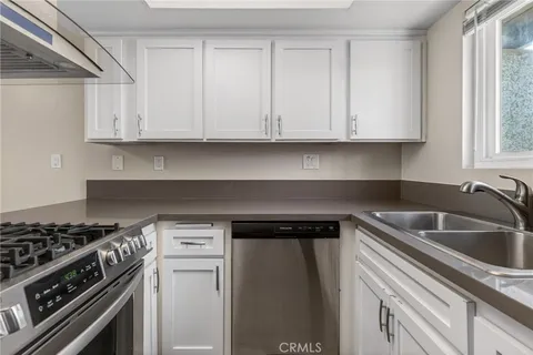 a kitchen with white cabinets and a stove top oven