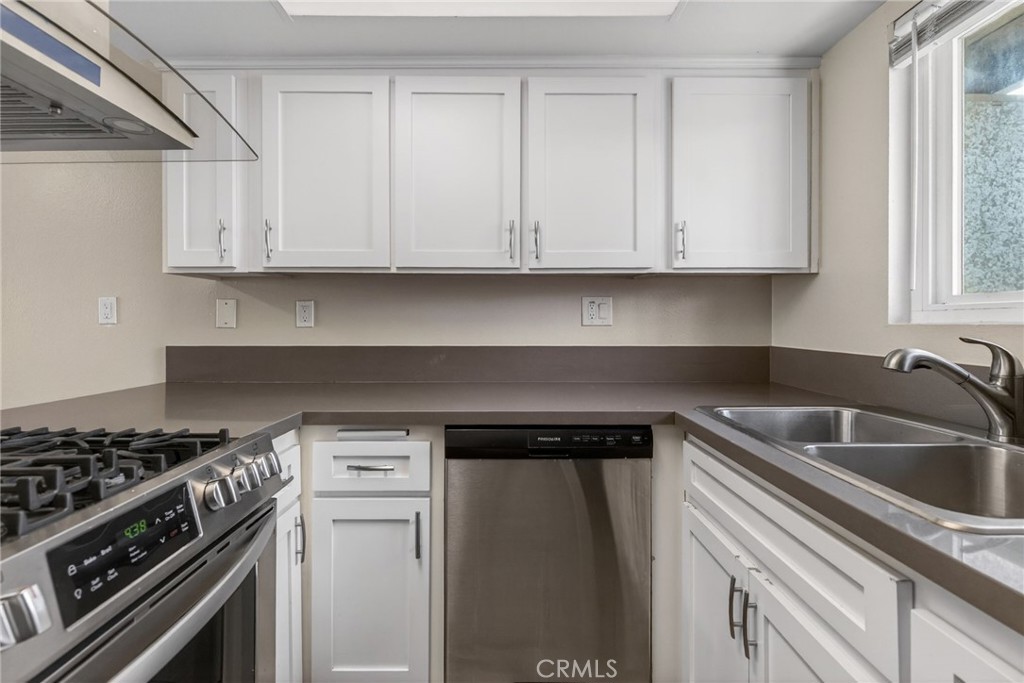 2891 Canyon Crest, Unit 32 Riverside, CA 92507 - Photo 11 of 27 a kitchen with white cabinets and a stove top oven