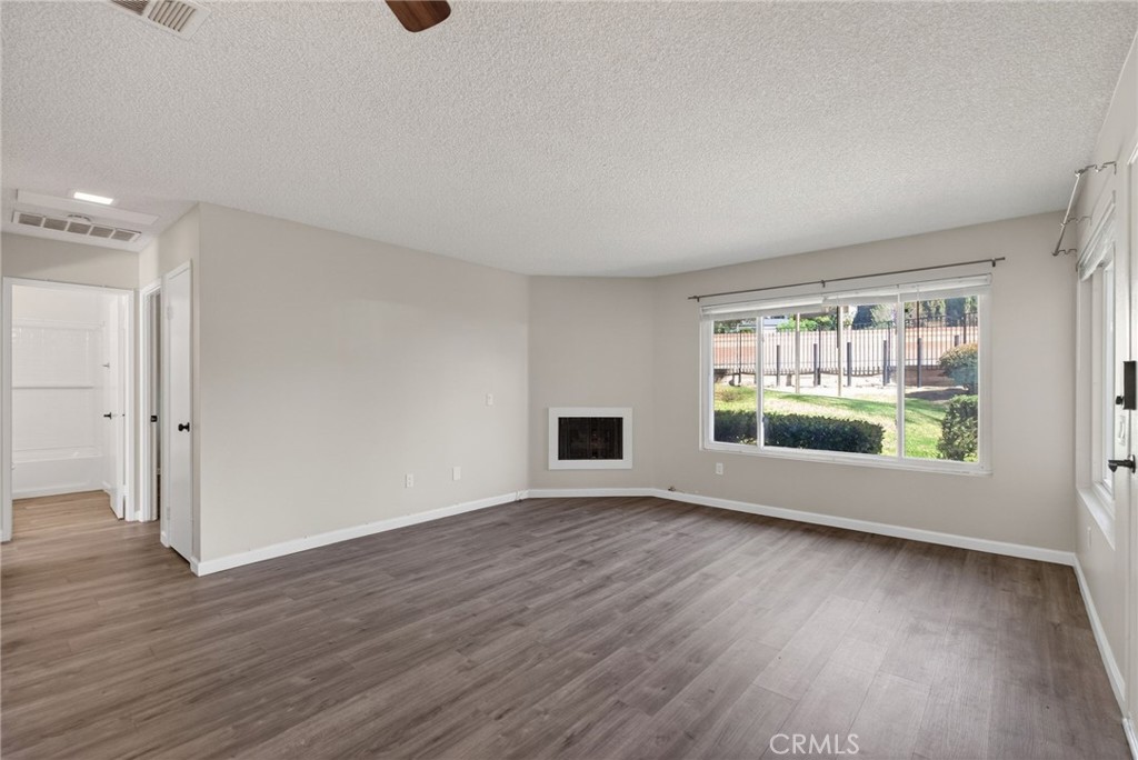 2891 Canyon Crest, Unit 32 Riverside, CA 92507 - Photo 6 of 27 a view of an empty room with wooden floor and a window
