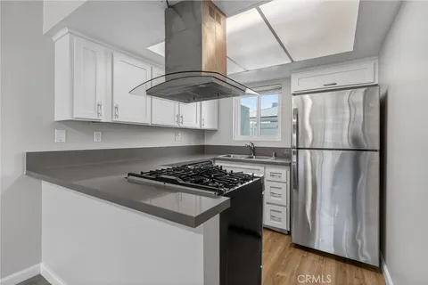 a kitchen with stainless steel appliances granite countertop a stove a refrigerator and a sink