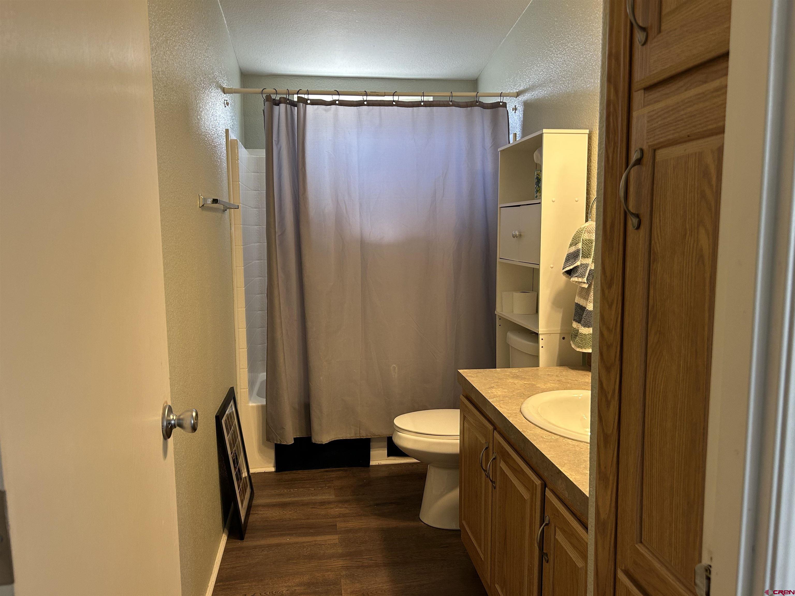 a bathroom with a granite countertop sink toilet and shower