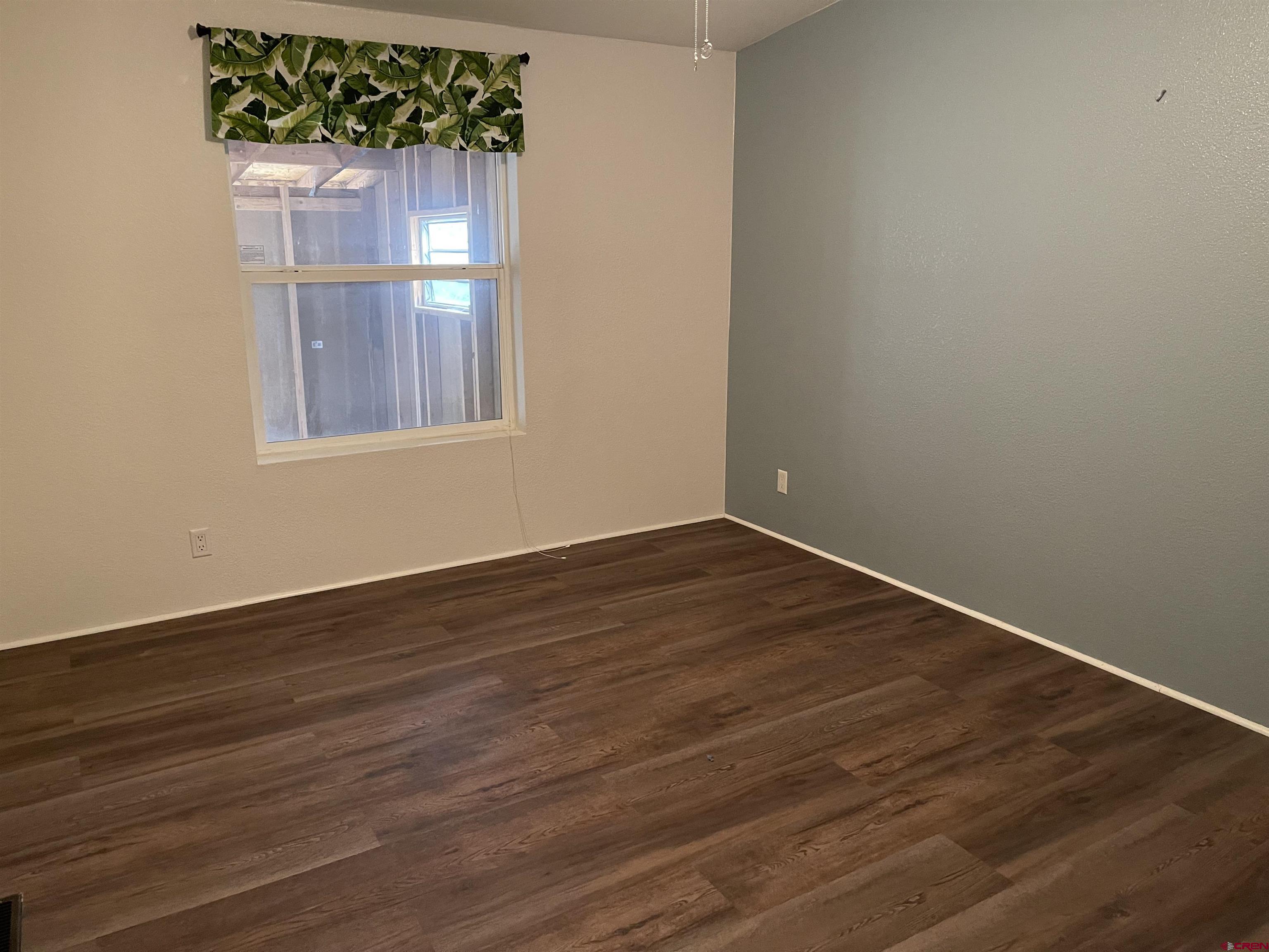 28260 Highway 160, Unit 1 Cortez, CO 81321 - Photo 13 of 21 an empty room with wooden floor and windows