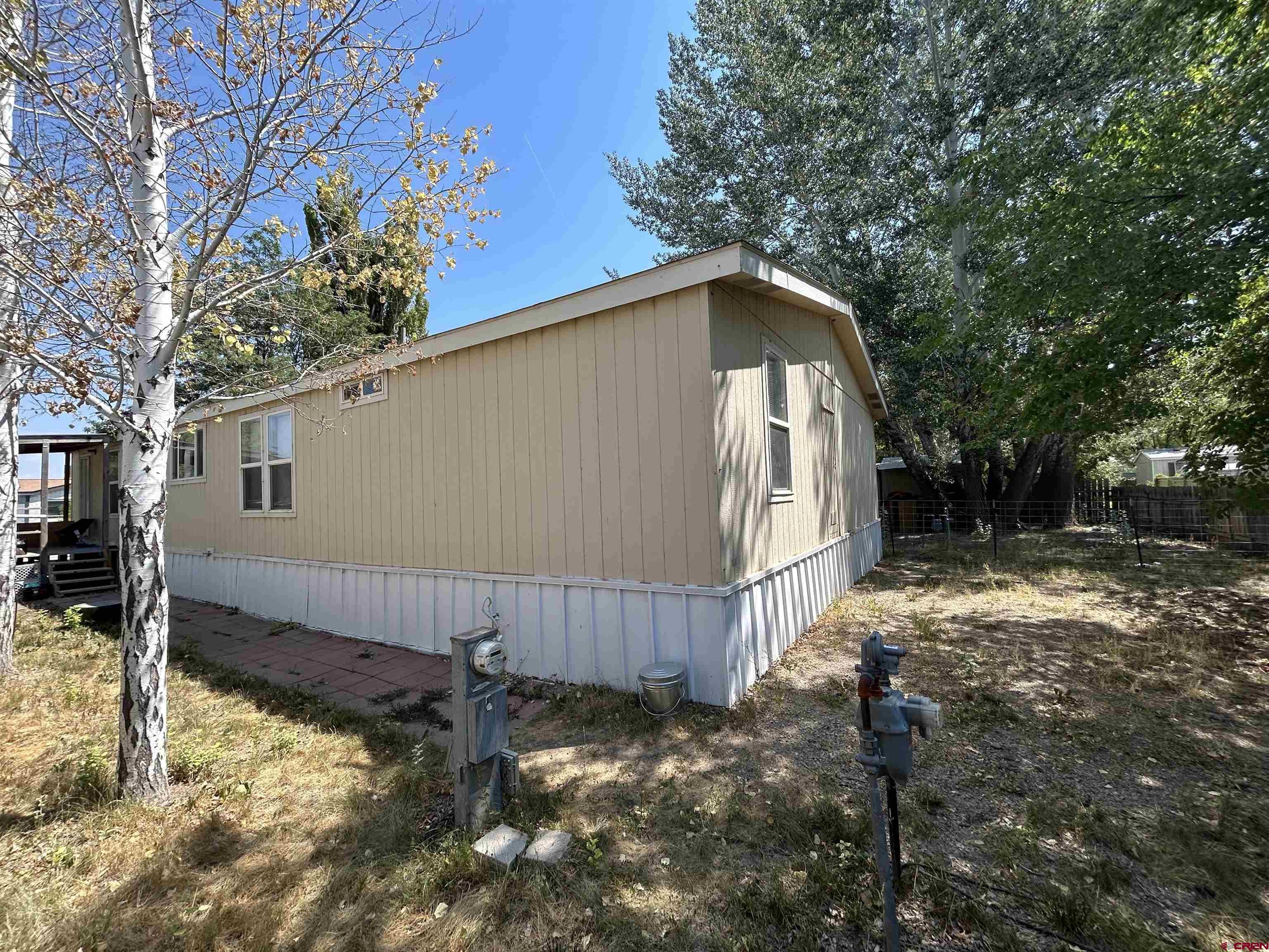 28260 Highway 160, Unit 1 Cortez, CO 81321 - Photo 15 of 21 a backyard of a house with large trees and wooden fence