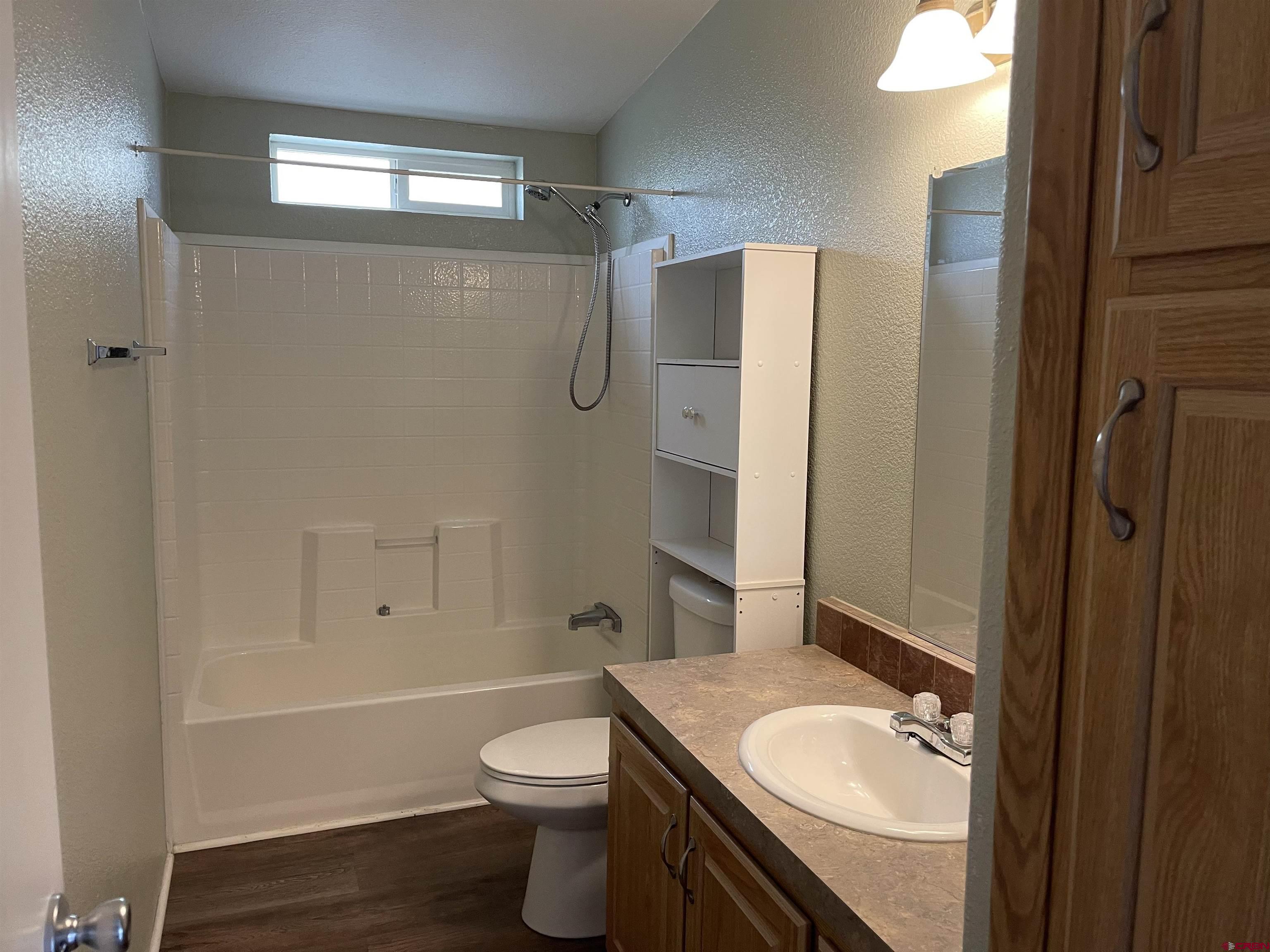 28260 Highway 160, Unit 1 Cortez, CO 81321 - Photo 18 of 21 a bathroom with a granite countertop sink toilet and shower