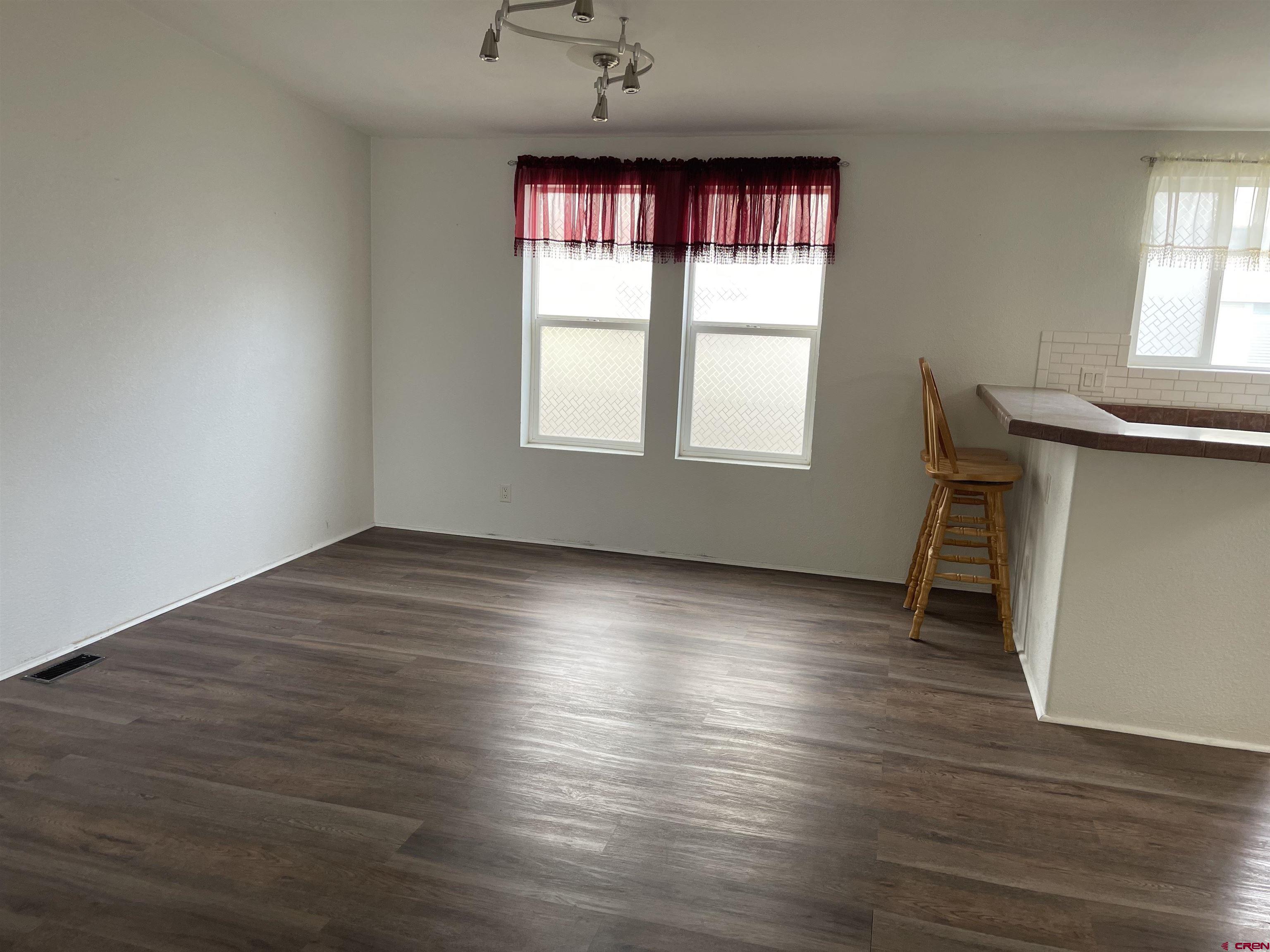 28260 Highway 160, Unit 1 Cortez, CO 81321 - Photo 19 of 21 an empty room with wooden floor and windows