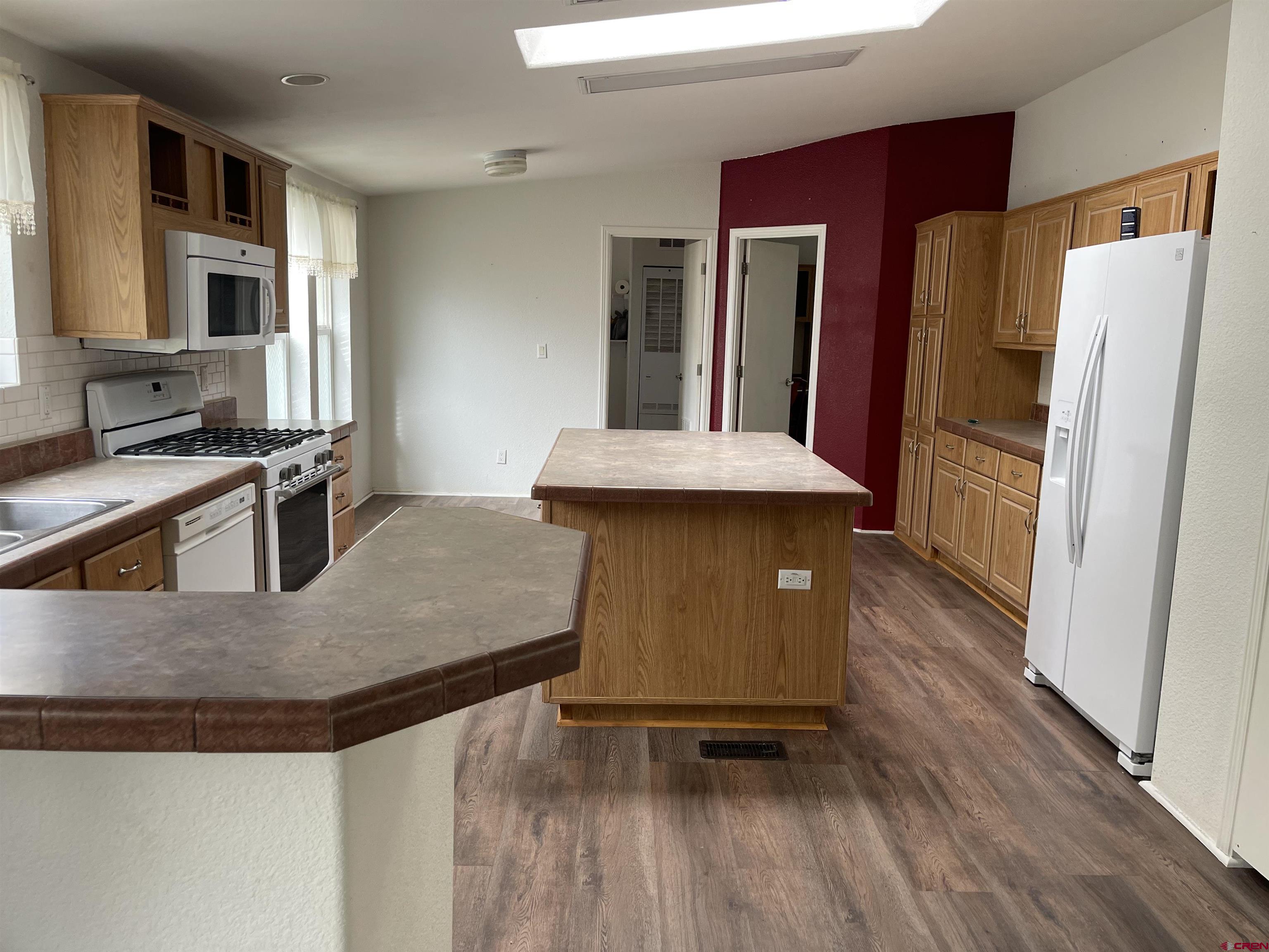 28260 Highway 160, Unit 1 Cortez, CO 81321 - Photo 21 of 21 a kitchen with stainless steel appliances granite countertop a refrigerator a stove and a sink with wooden floor