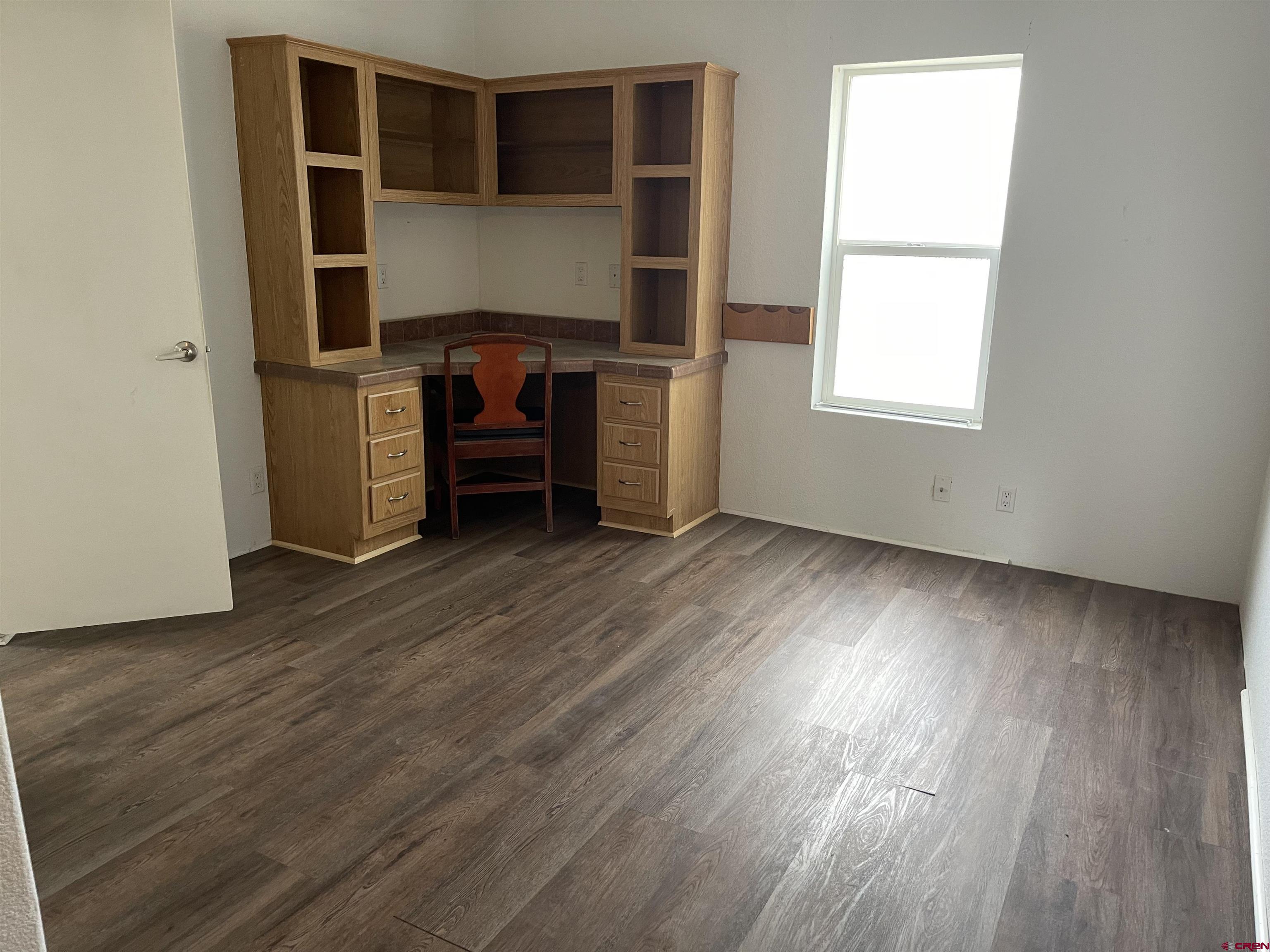 28260 Highway 160, Unit 1 Cortez, CO 81321 - Photo 6 of 21 an empty room with wooden floor and windows