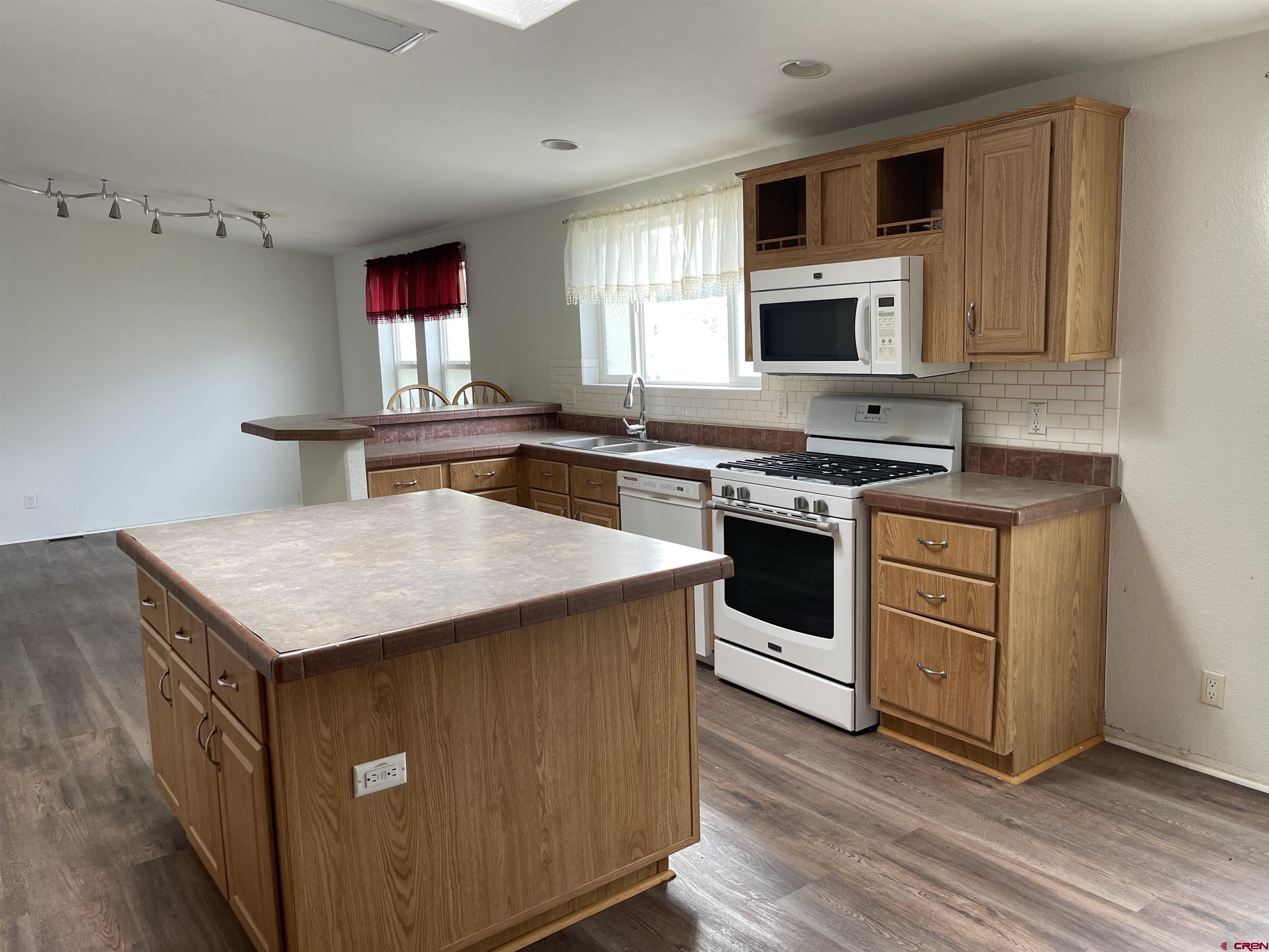 28260 Highway 160, Unit 1 Cortez, CO 81321 - Photo 8 of 21 a kitchen with stainless steel appliances a stove a sink dishwasher a microwave oven and a refrigerator
