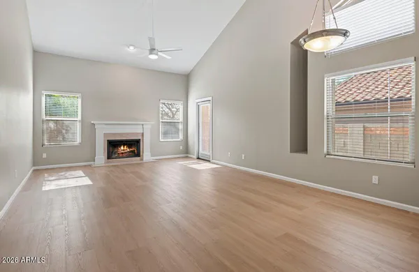 a view of empty room with fireplace and wooden floor