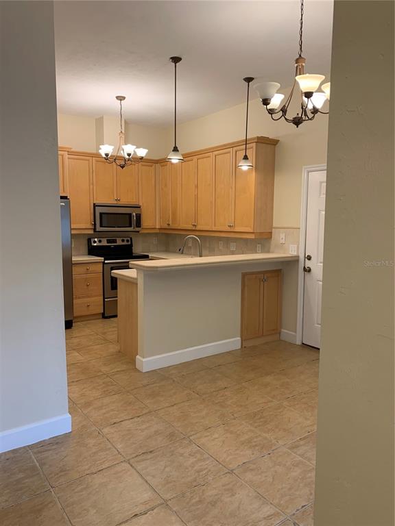 187 Southwest 129 Terrace Newberry, FL 32669 - Photo 19 of 39 a kitchen with kitchen island a stove a sink a counter space and cabinets
