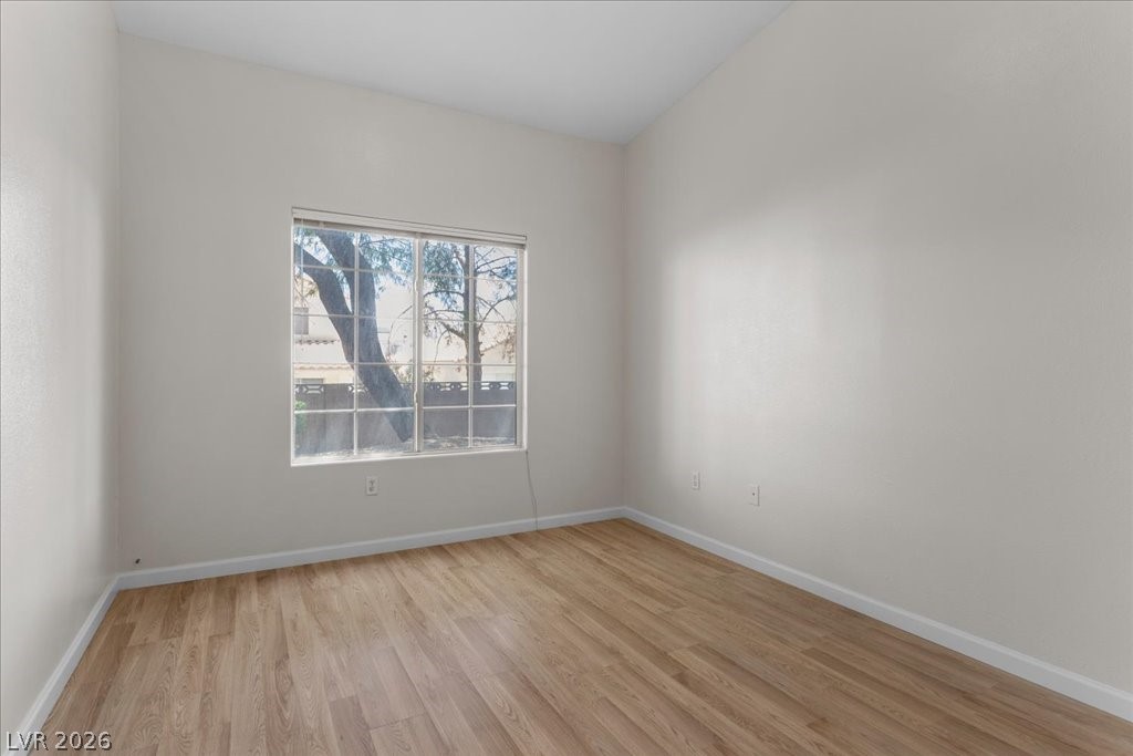 1881 West Alexander Road, Unit 1037 North Las Vegas, NV 89032 - Photo 20 of 31 A spacious second bedroom with neutral walls and warm wood flooring awaits personalization.