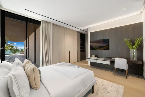 a spacious bedroom with a bed and glass window