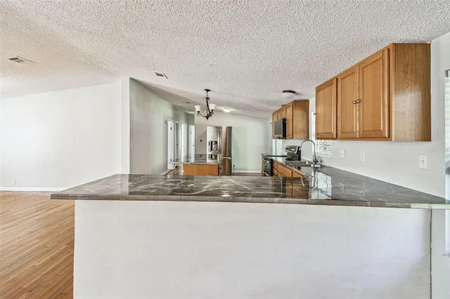 a view of kitchen island a sink wooden floor and kitchen view
