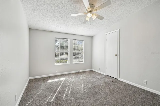 an empty room with a ceiling fan and a window