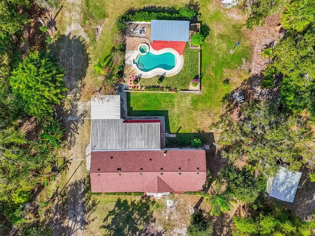 an aerial view of a house with a yard and parking