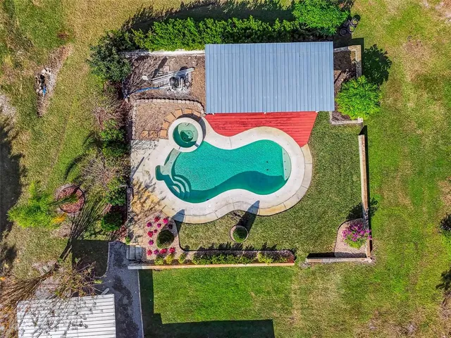 an aerial view of a house with a swimming pool outdoor seating and yard