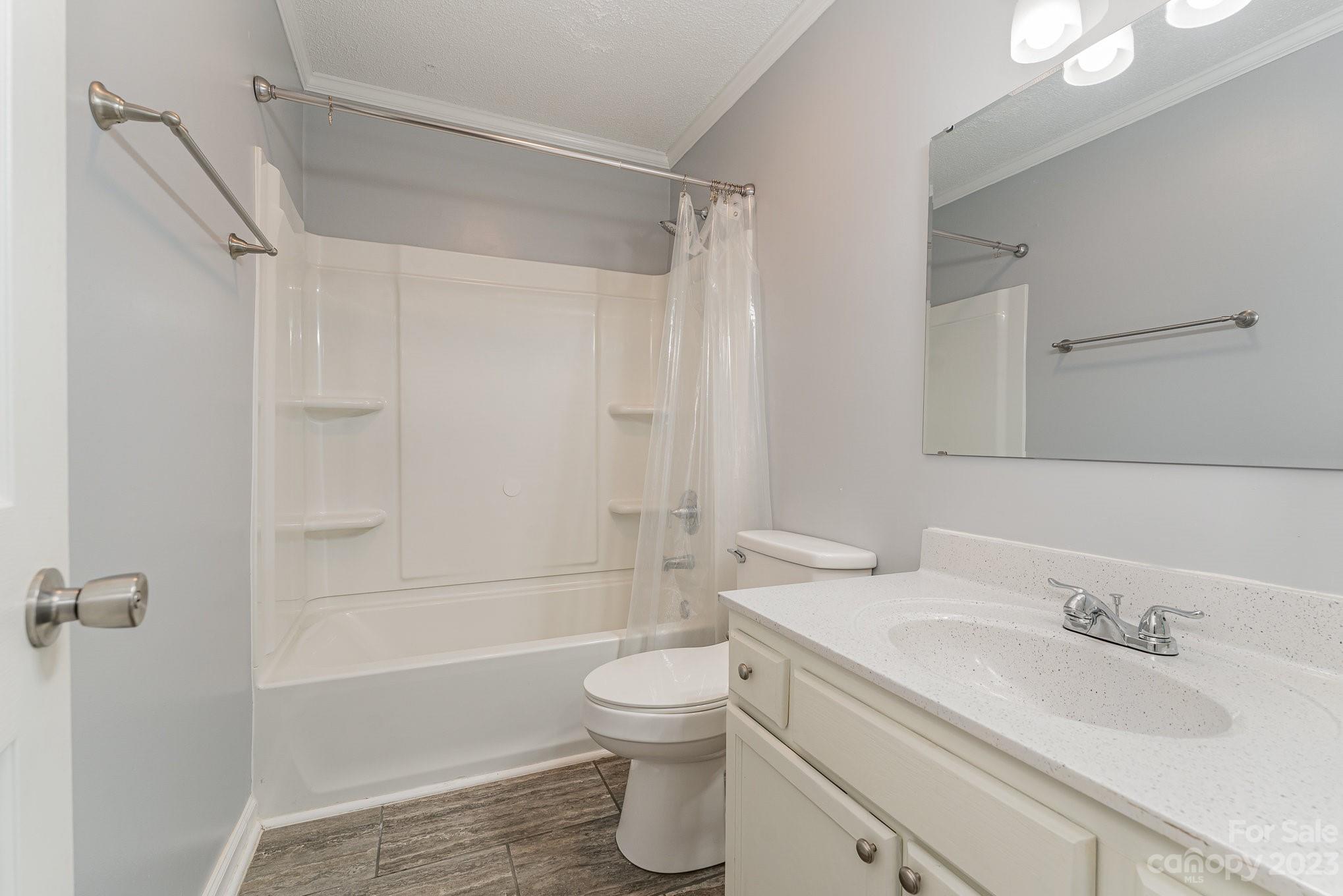 873 Gladstone Road Mocksville, NC 27028 - Photo 19 of 29 a bathroom with a granite countertop sink toilet a shower and a bathtub