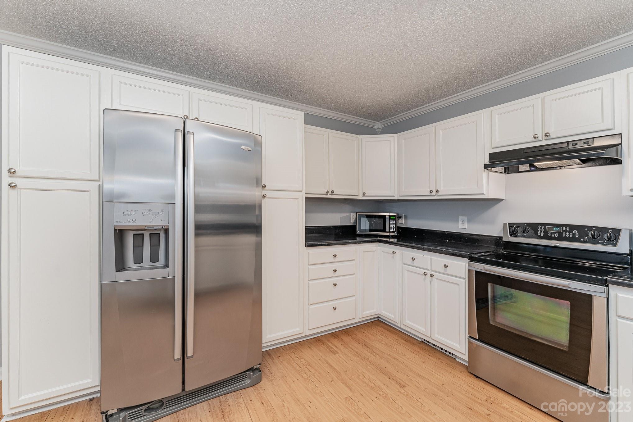 873 Gladstone Road Mocksville, NC 27028 - Photo 10 of 29 a kitchen with cabinets stainless steel appliances and wooden floor