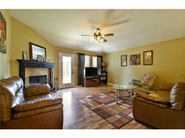 11612 Timber Heights Drive Austin, TX 78754 - Photo 4 of 28 Staged previously. Warm, inviting living area features durable hardwood flooring and a stately fireplace, ideal for gathering.