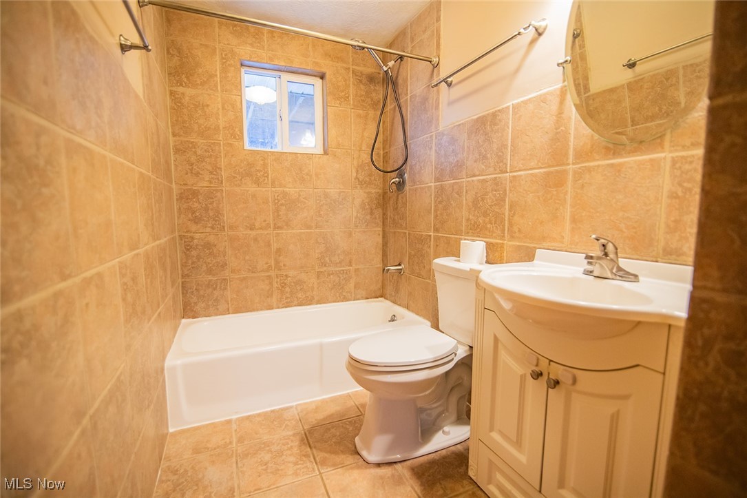 91 Mike Street Washington, WV 26181 - Photo 18 of 42 Bathroom featuring vanity, tile walls, shower / tub combination, and light tile patterned flooring