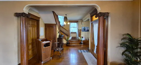 a view of a hallway with wooden floor and stairs