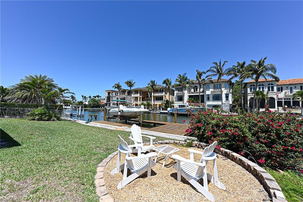 177 Channel Drive Naples, FL 34108 - Photo 20 of 23 a view of a chair and tables in the garden
