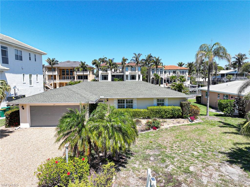177 Channel Drive Naples, FL 34108 - Photo 2 of 23 a front view of a multi story building with yard