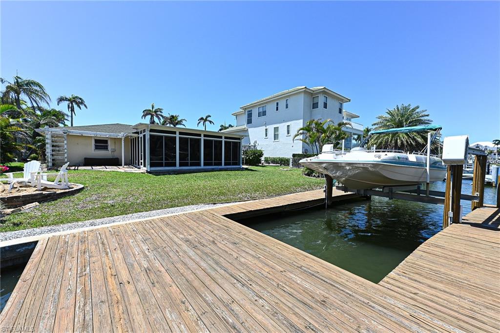 177 Channel Drive Naples, FL 34108 - Photo 22 of 23 a view of a house with pool fire pit and chairs in patio
