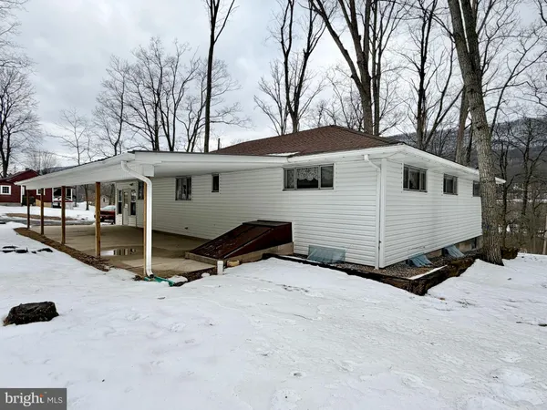 a front view of a house with a yard covered in snow