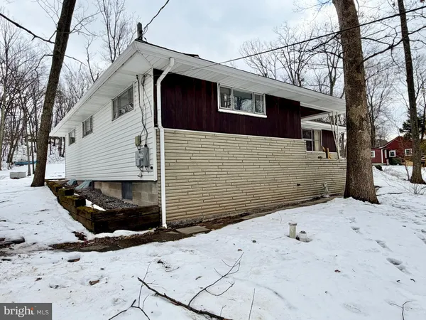 a view of a house with a wooden bench