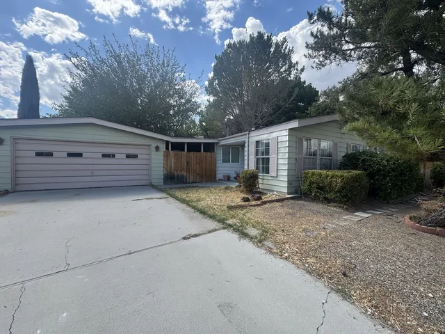 a backyard of a house with garage and outdoor seating