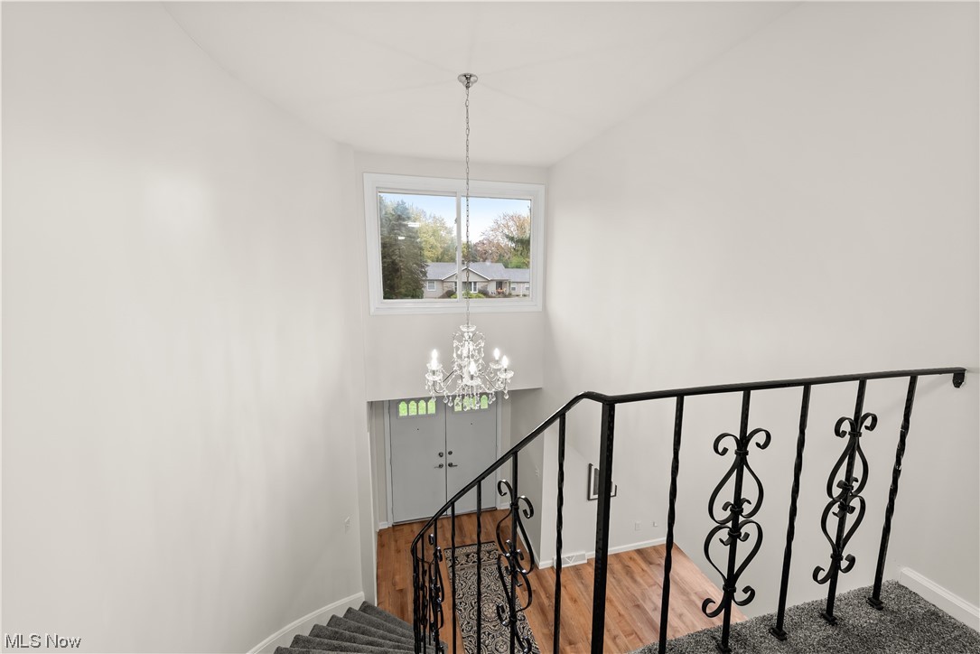 896 Beechers Brook Road Cleveland, OH 44143 - Photo 20 of 35 Staircase featuring hardwood / wood-style flooring and a notable chandelier
