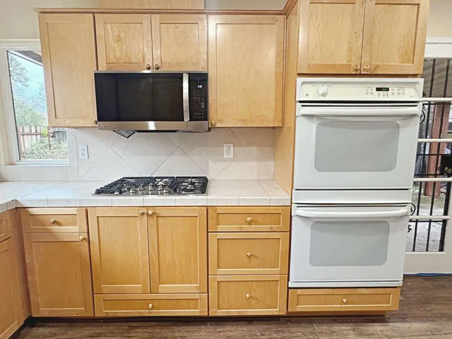 a kitchen with stainless steel appliances white cabinets and a microwave oven