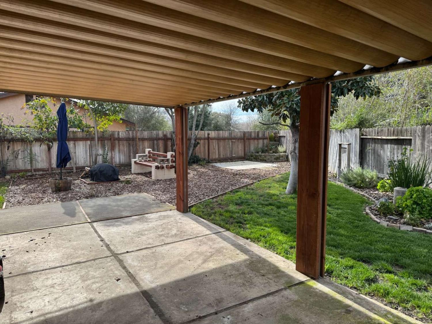 6249 Sunmist Way Citrus Heights, CA 95621 - Photo 5 of 24 a view of a backyard with table and chairs under an umbrella with a barbeque grill