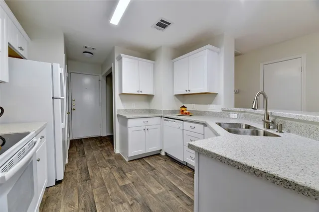 a kitchen with white cabinets and white appliances
