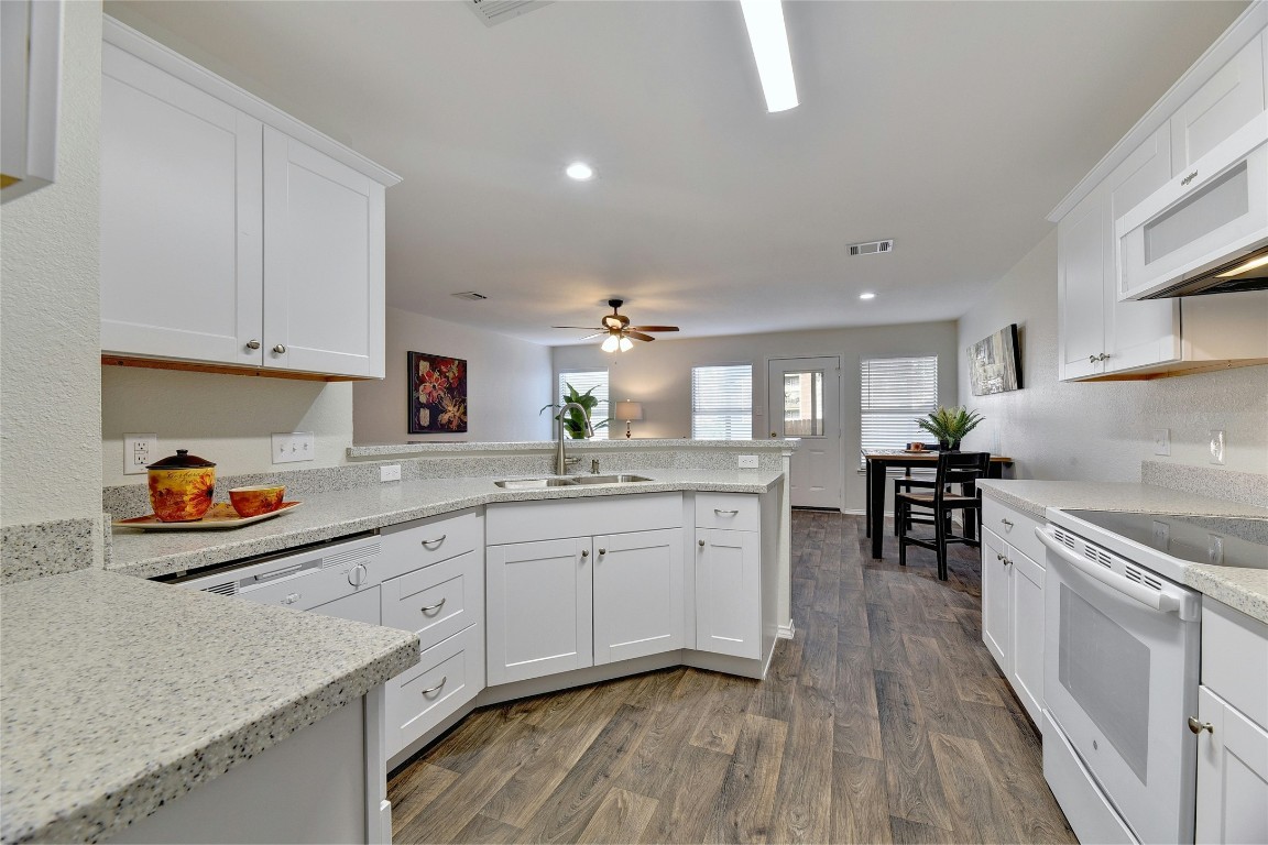 9716 Sugar Hill Drive, Unit A Austin, TX 78748 - Photo 12 of 40 a kitchen that has a lot of cabinets a sink and wooden floor