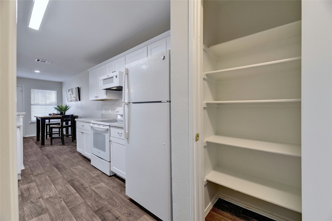 9716 Sugar Hill Drive, Unit A Austin, TX 78748 - Photo 13 of 40 a kitchen with white cabinets and white appliances