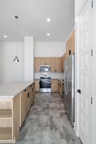 a kitchen with granite countertop a refrigerator and a stove