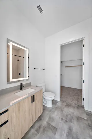 a bathroom with a toilet sink and mirror