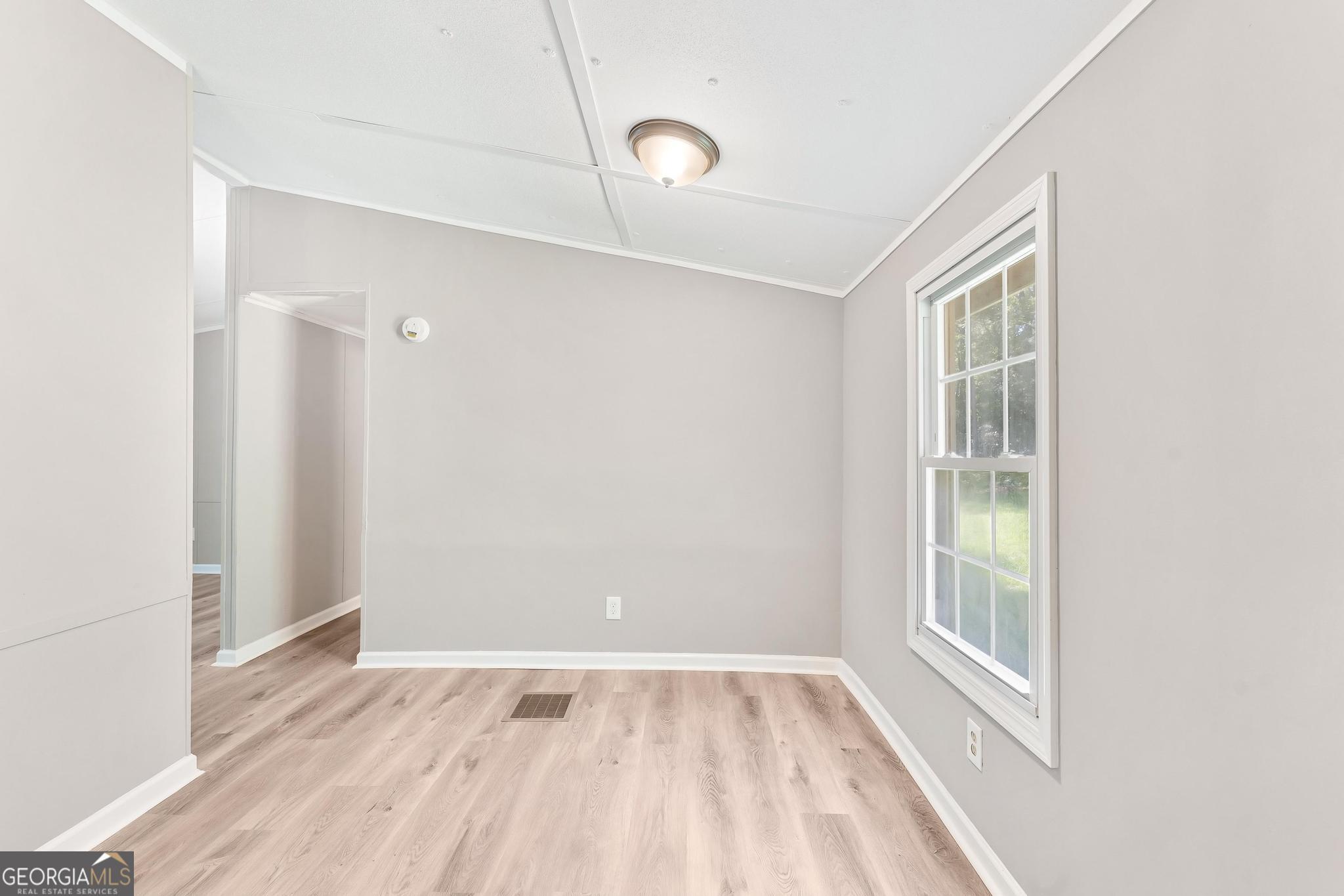 1528 Hodges Mill Road Hartwell, GA 30643 - Photo 13 of 37 a view of an empty room with wooden floor and a window