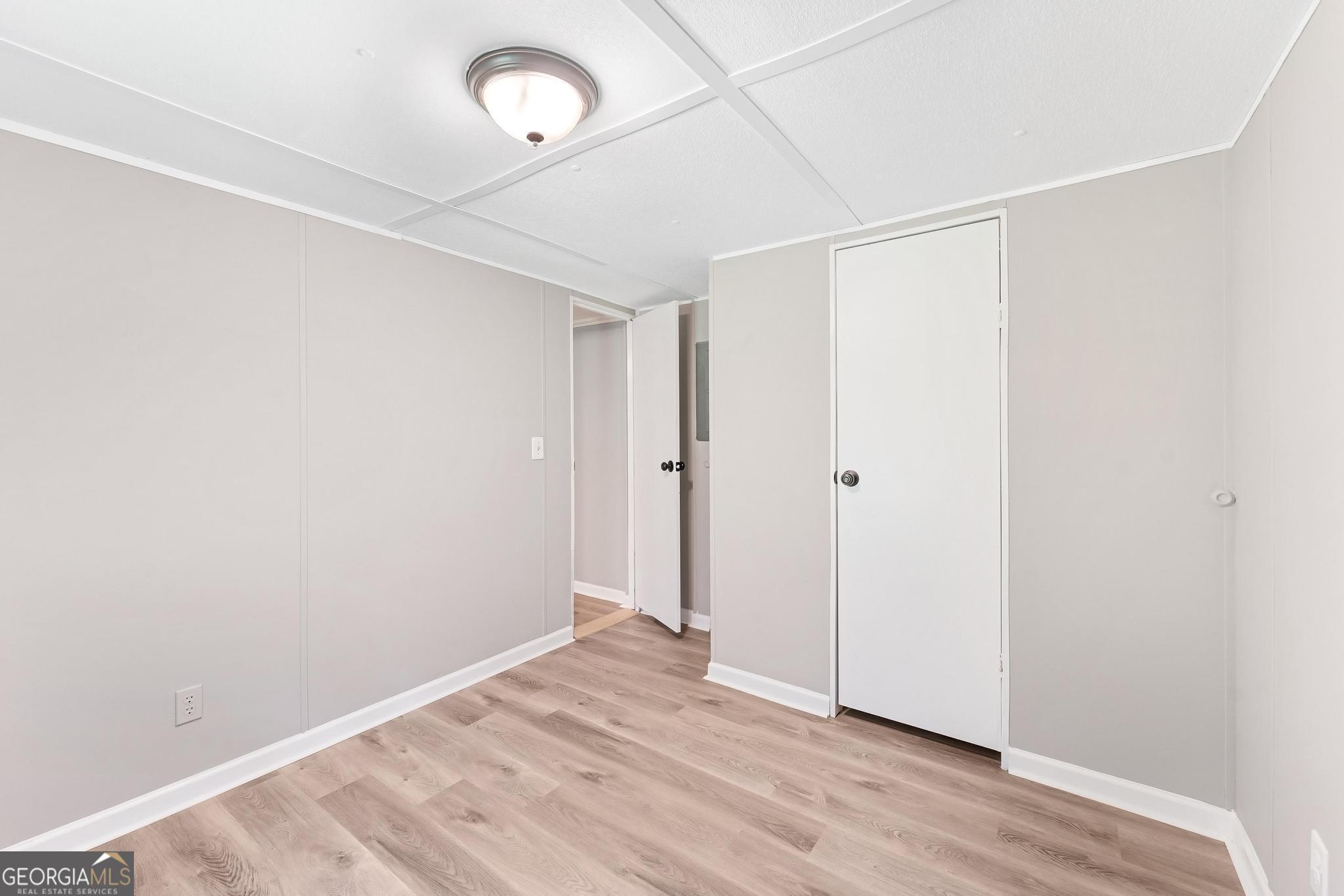 1528 Hodges Mill Road Hartwell, GA 30643 - Photo 19 of 37 an empty room with wooden floor and windows