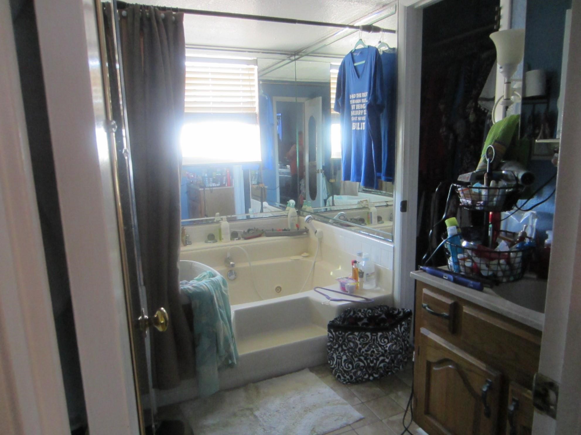 314 Shark Lane Surfside Beach, TX 77541 - Photo 6 of 12 a bathroom with a bathtub a mirror and sink
