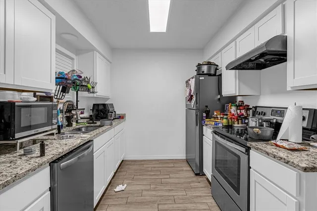 a kitchen with stainless steel appliances granite countertop a sink stove and refrigerator