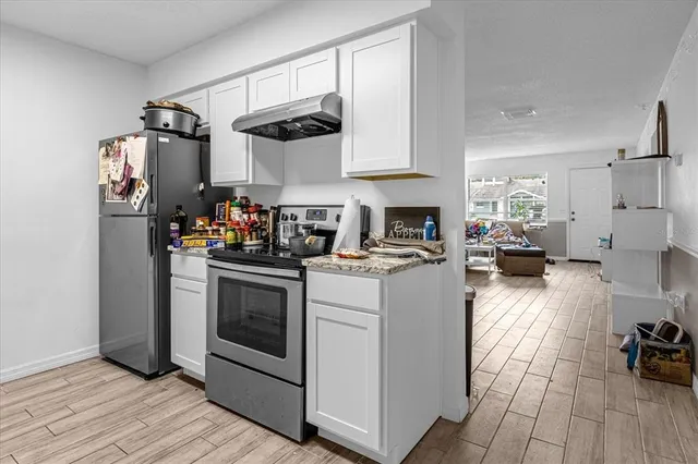 a kitchen with refrigerator and cabinets
