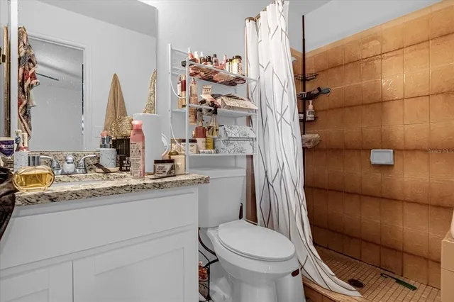 a bathroom with a granite countertop sink toilet and shower