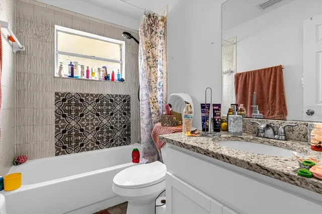 a bathroom with a bathtub sink vanity mirror and toilet