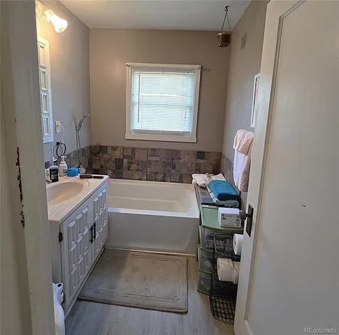 a bathroom with a tub sink and a mirror