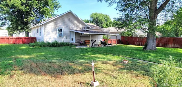 a view of a house with a yard and sitting area