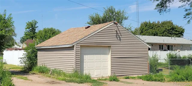 a view of a white house next to a yard