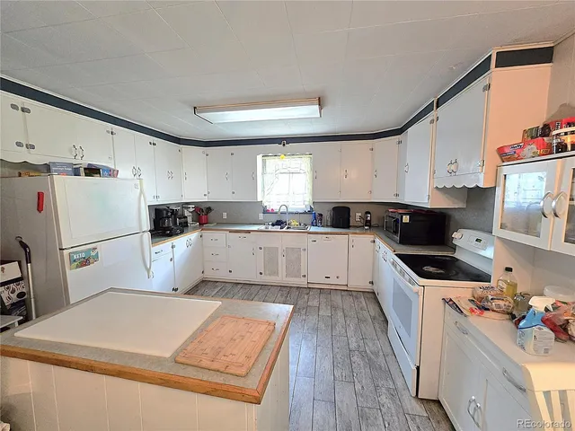 a kitchen with sink a microwave and refrigerator